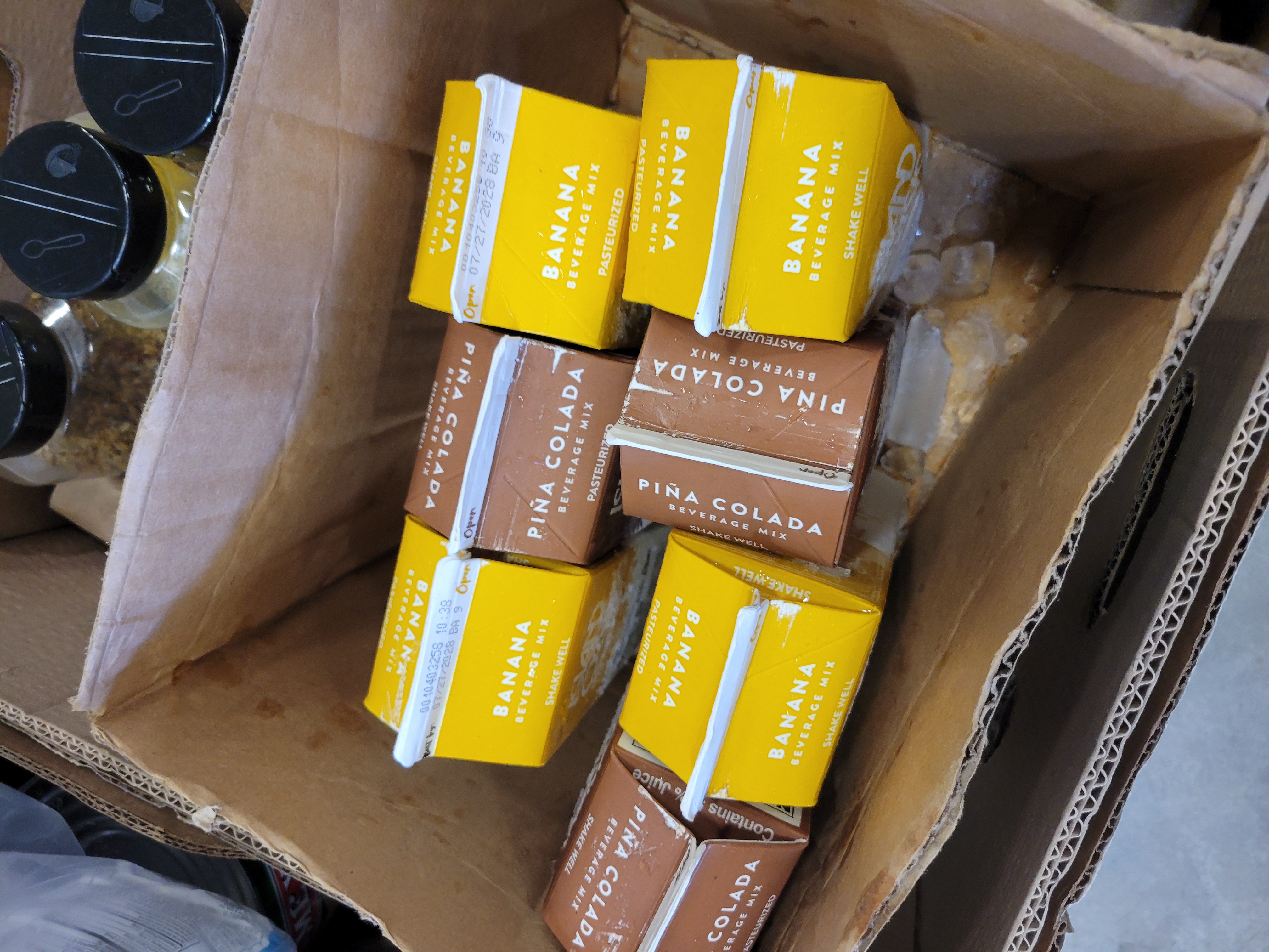 Cardboard box full of cartons of banana and pina colada beverage mixes.